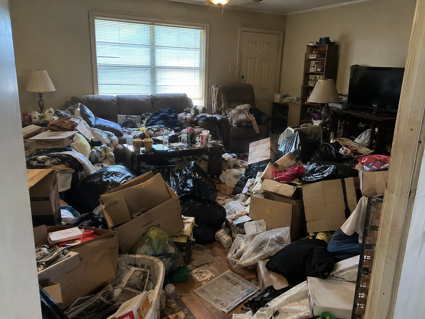 Hoarded living room before professional cleanup by Extreme Hoarding Cleaners